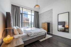 a bedroom with a bed and a large window at 1 Bedroom Apartment with city view in Dubai