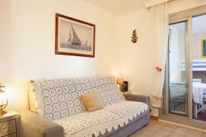 a living room with a couch and a sailboat on the wall at Studio proche des plages in Le Pradet