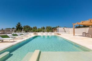 a swimming pool with chaise lounge chairs and a pool at Villa Dei Lidi - HomeSalento com in Torre San Giovanni Ugento