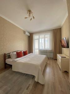 um quarto com uma cama e uma ventoinha de tecto em Однокомнатные апартаменты на Экспо em Taldykolʼ