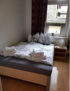 1 cama con sábanas y almohadas blancas y ventana en Urlaub am Meer in eigener 50qm Wohnung en Wilhelmshaven