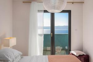 a bedroom with a bed and a view of the ocean at Villa Allegra with 32msq heated pool, 300m far from sandy beaches, open sea view in Omiš +42 photos