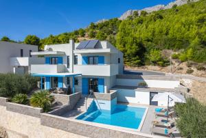 a villa with a swimming pool and a mountain at Villa Allegra with 32msq heated pool, 300m far from sandy beaches, open sea view in Omiš