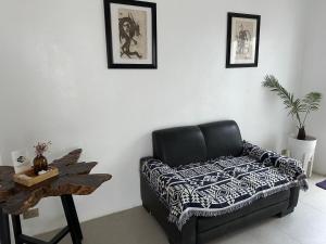 a black leather couch sitting in a room with a table at Kasamigos Guesthouse with Fast Internet in Puerto Princesa City