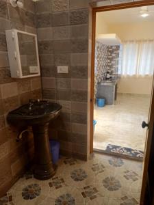 uma casa de banho com um lavatório e um espelho em SAI HOMESTAY em Agonda