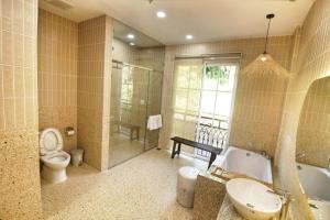 a bathroom with a toilet and a tub and a sink at Aurora Phu Quoc Hotel & Cafe in Phú Quốc