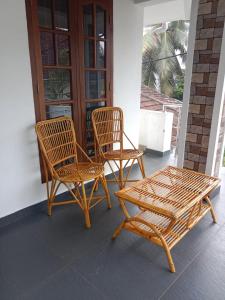 twee stoelen en een tafel op een veranda bij Kochi Bella Villa in Cochin