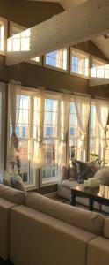 - un salon avec un grand canapé et des fenêtres dans l'établissement Waterfront vacation home, à Kingsville