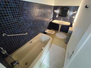 Baño pequeño con bañera y lavamanos en Villa Loha Maison de vacances, en Saint-Gaudens