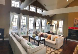 una gran sala de estar con sofás blancos y chimenea. en Waterfront vacation home en Kingsville