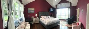um quarto com paredes vermelhas, uma cama e janelas em Waterfront vacation home em Kingsville