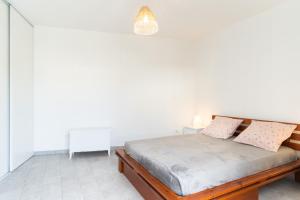 um quarto branco com uma cama e um candeeiro em Bernard em Toulouse