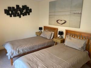 two beds sitting next to each other in a bedroom at River Ground Floor Apartment - 70 Skipper Way in Saint Neots