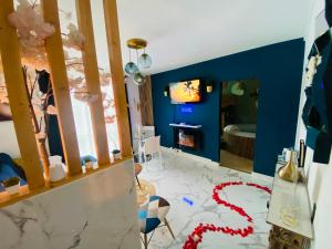 uma sala de estar com uma parede azul e uma televisão em Exotic spa em Poissy