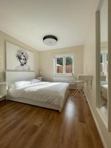 a white bedroom with a bed and a desk at The Ridge Bungalow, at the highest point in the Heart of Cheshire in Frodsham