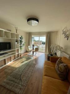 a living room with a couch and a television at The Ridge Bungalow, at the highest point in the Heart of Cheshire in Frodsham