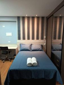 Un dormitorio con una cama con dos zapatos blancos. en Stay GRU - Loft Completo próx GRU airport - Guarulhos, en Guarulhos