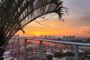 um pôr-do-sol a partir de uma varanda com vista para a cidade em Stay GRU - Loft Completo próx GRU airport - Guarulhos em Guarulhos