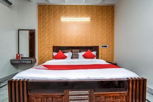 1 dormitorio con 1 cama grande con almohadas rojas en OYO Forever Banquet & Rooms en Nueva Delhi