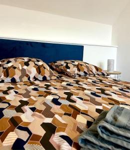 Dormitorio con cama con edredón estampado en Appartement Saphir - 3 pers. - Sedan, en Sedan