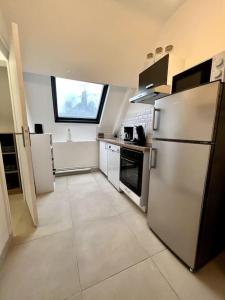 cocina con electrodomésticos blancos y ventana grande en Appartement Saphir - 3 pers. - Sedan, en Sedan