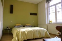 una camera con un letto in una stanza con una finestra di B&B La Chambre du Zodiaque a Bruxelles
