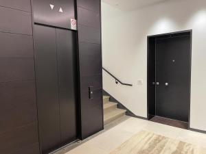 米蘭的住宿－IMHOME - Dante，大楼内带两部电梯和楼梯的走廊