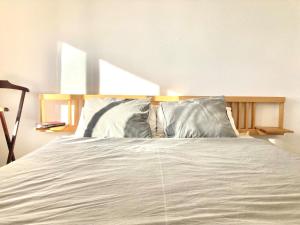 a white bed with pillows in a bedroom at Beautiful Mediterranean views in central Torremolinos in Torremolinos