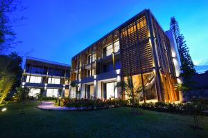 a large building with a lawn in front of it at Le Petit Village Boutique Hotel & Spa in Kampala