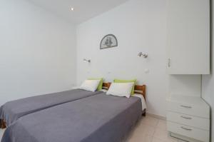 a white bedroom with a bed and a white cabinet at Windmill Naxos in Naxos Chora