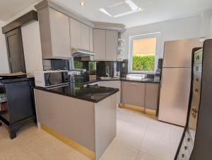 eine große Küche mit weißen Geräten und einem Fenster in der Unterkunft Beachfront 5-bedroom Villa - by KohChangVillas in Ko Chang