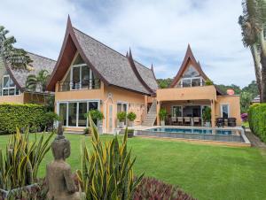 een huis met een zwembad en een tuin bij Beachfront 5-bedroom Villa in Ko Chang