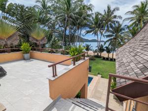 een balkon met uitzicht op de oceaan en palmbomen bij Beachfront 5-bedroom Villa in Ko Chang