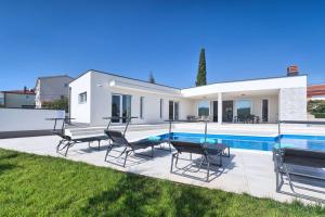 a villa with a swimming pool and lawn at Aura in Pula