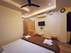 a bedroom with a bed and a flat screen tv at Hotel MTown in Port Blair