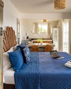 a bedroom with a blue bed with a laptop on it at Loft Grécia In in Arraial do Cabo