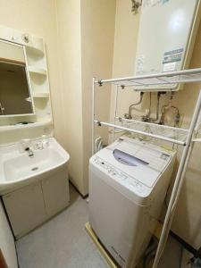 ein kleines Bad mit einer Waschmaschine und einem Waschbecken in der Unterkunft 中島公園徒歩3分、Susukino（薄野）内、格安有料駐車場あり(205号室） in Sapporo