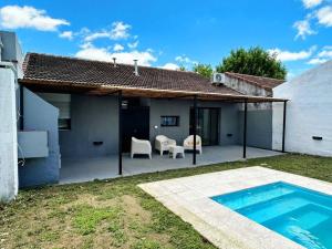 a patio with a swimming pool and a house at Casa impecable con Pileta, Garage in Azul