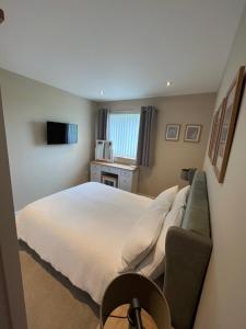 ein Schlafzimmer mit einem Bett, einem Sofa und einem TV in der Unterkunft Loanside Lodge, Self-Catering, Holm, Orkney. in Saint Marys