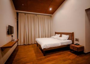 Кровать или кровати в номере The Odyssey Coorg