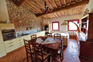 Podere Calvaiola في بمونتيكاتيني فال دي سيسينا: مطبخ وغرفة طعام مع طاولة وغرفة نوم