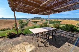 a table and chairs under a pergola on a patio at Podere Calvaiola in Montecatini Val di Cecina
