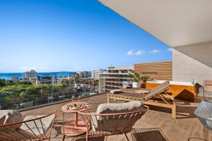 einen Balkon mit Stühlen und einem Tisch auf einem Gebäude in der Unterkunft Aubamar Suites & Spa in Playa de Palma