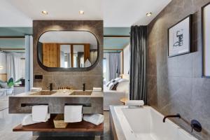 een badkamer met een bad en een grote spiegel bij Aubamar Suites & Spa in Playa de Palma