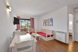 a living room with a red couch and a table at Apartamentos Pabisa Orlando in Playa de Palma