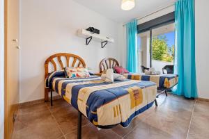 two beds in a room with blue curtains at Panorámica Golf Resort in Sant Jordi +22 photos