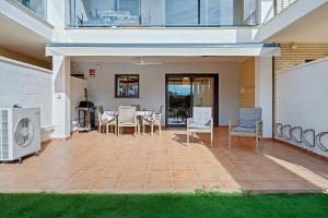 a patio with chairs and a table in a house at Panorámica Golf Resort in Sant Jordi