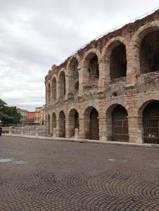 a large brick building with arches on a street at La Casa di Mia in Verona