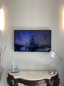 Un televisor de pantalla plana colgado en una pared con una mesa. en Flat no Itaim, en São Paulo