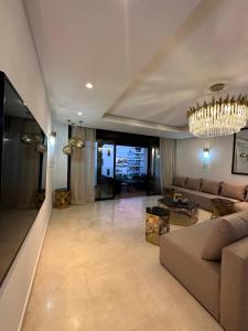a living room with a couch and a chandelier at Saphir penthouse ocean view in Casablanca